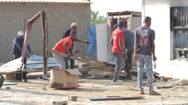 Angry community members looting the tavern of the suspected killer before burning it down. Photo by Tumelo Mofokeng